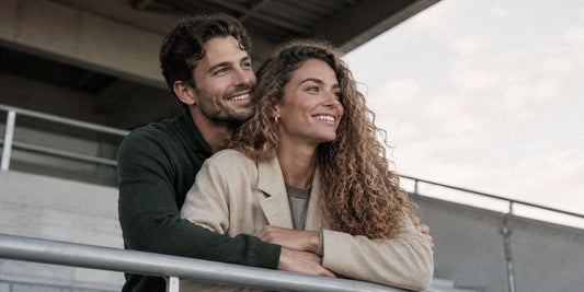 couple smiling (women has curly hair).